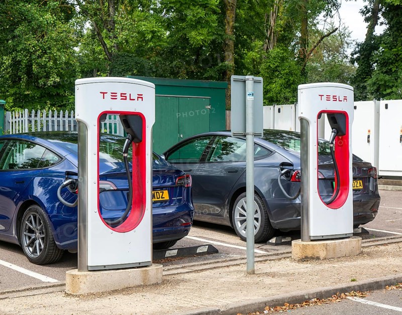 Tesla Supercharger station charging bays for electric vehicles at service station, M25 South Mimms services, Hertfordshire, England, UK