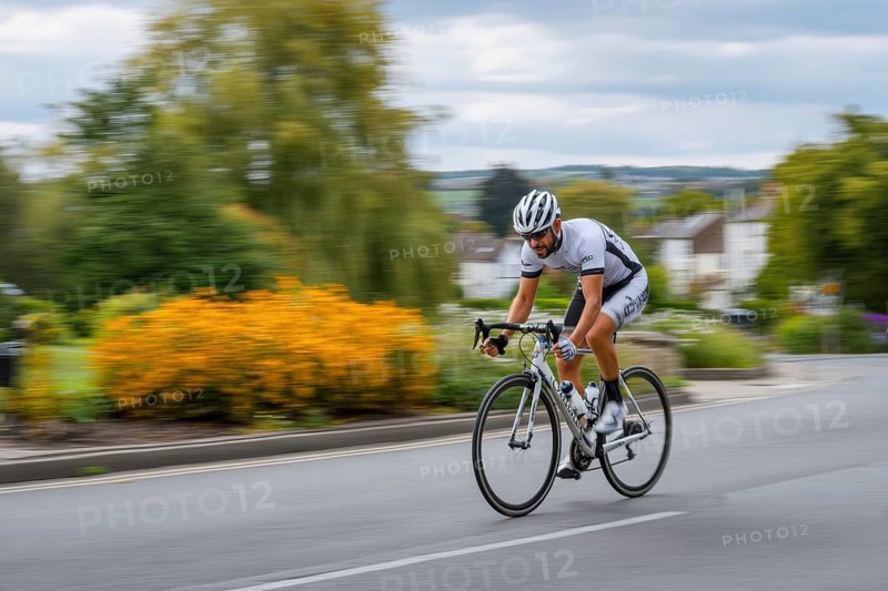 A cyclist, racing cyclist rides his racing bike fast on a road through a rural area, AI generated, AI generated