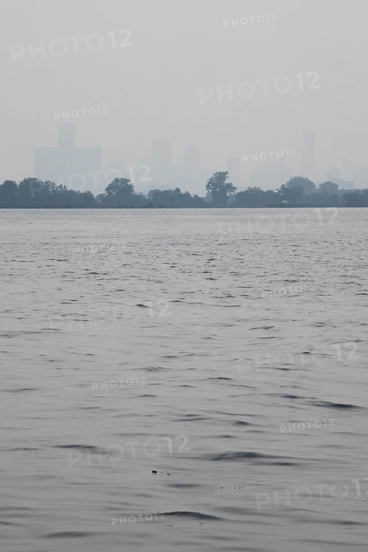 Detroit, Michigan USA - 4 August 2025 - Smoke from Canadian wildfires nearly erases the downtown skyline, as seen from about five miles up the Detroit River. The city's air quality is listed as unhealthy