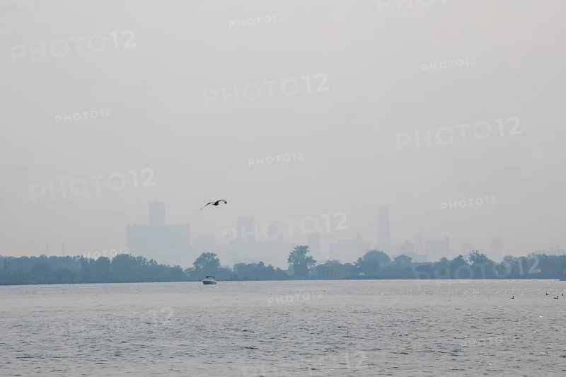 Detroit, Michigan USA - 4 August 2025 - Smoke from Canadian wildfires nearly erases the downtown skyline, as seen from about five miles up the Detroit River. The city's air quality is listed as unhealthy