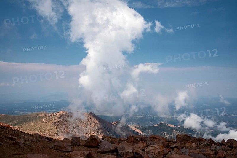 Colorado Springs, Colorado - Clourds rise near the summit of Pikes Peak, a 14, 115' mountain in Colorado's front range. Thousands of tourists visit, most by driving a steep road to the summit, or riding on a cog railway