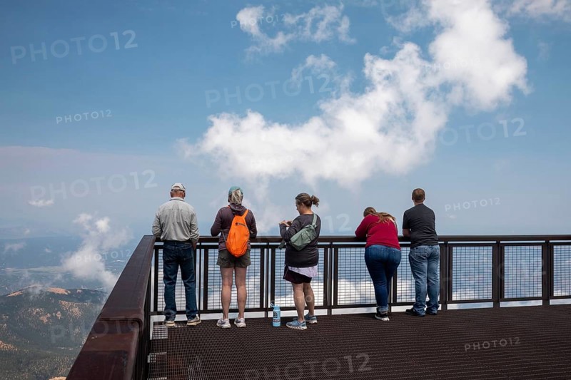 Colorado Springs, Colorado - Tourists line a viewint platform at the summit of Pikes Peak, a 14, 115' mountain in Colorado's front range. Thousands of tourists visit, most by driving a steep road to the summit, or riding on a cog railway