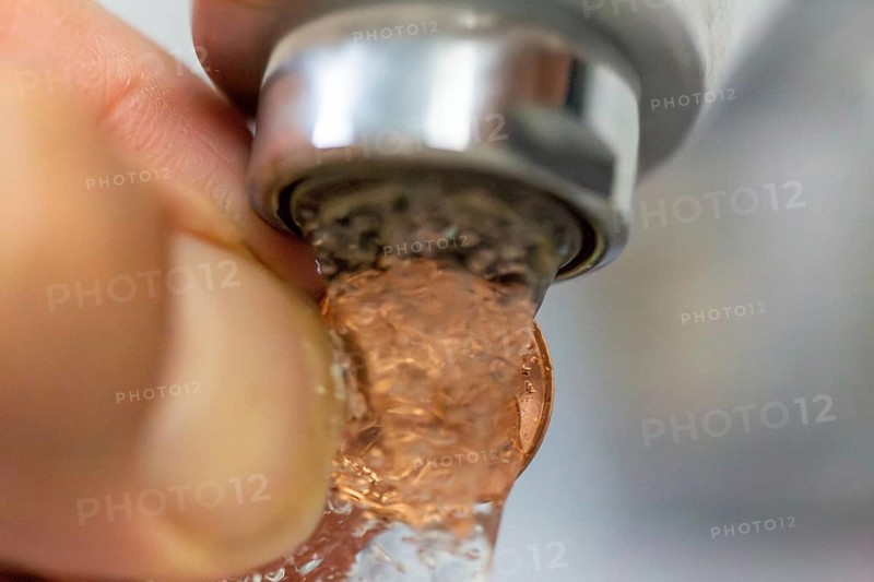 Symbolic image of a water cent: A cent piece under a running tap