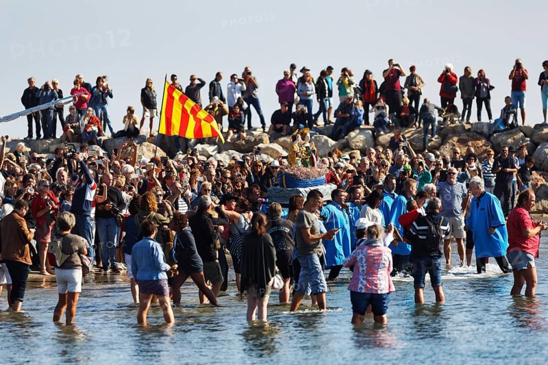 Pilgrimage, procession by the sea, pilgrims walking through water, statue of the Virgin Mary, crowd, Saintes-Maries-de-la-Mer, Camargue, France