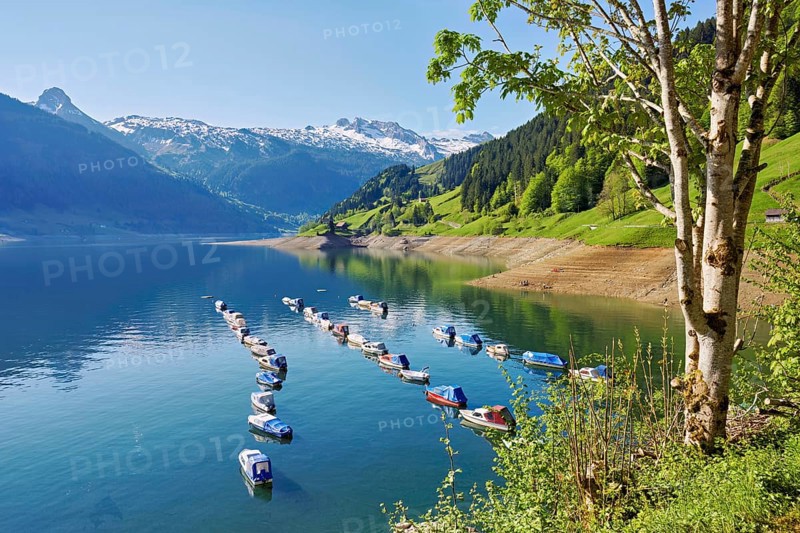 Motorboats moored at the reservoir, snow-covered Alps in the background, Lake Wägital, Canton Schwyz, Switzerland