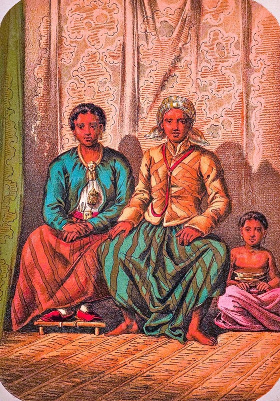 Seated Javanese family with father, mother and child, traditional clothing, headscarf, jacket, long skirt, shoes, barefoot, earrings, necklace, belt, interior with raffia rug, coloured drawing, Java, historical illustration 1877