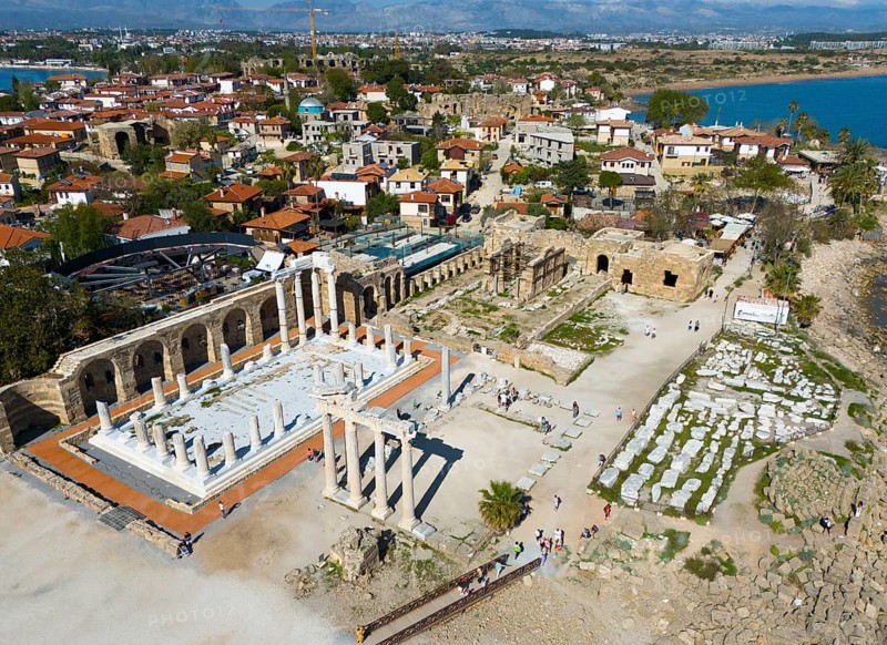 Ancient ruins next to a town overlooking the sea. Historical and scenic scenery, aerial view, Temple of Apollo, Side, Manavgat, Antalya Province, Turkey