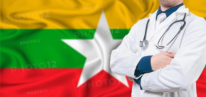 Myanmar healthcare concept. Male doctor on Myanmar flag. Doctor with crossed arms on Myanmar flag