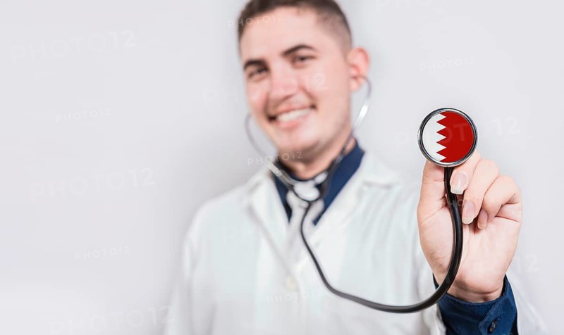 Doctor showing stethoscope with Bahrain flag. Bahrain national healthcare concept