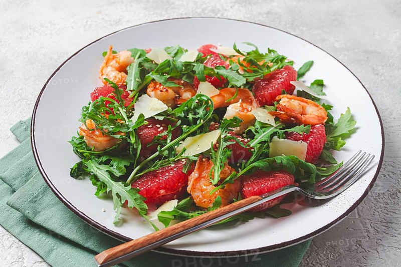 Fresh shrimp salad with arugula, grapefruit, and parmesan served in a bowl