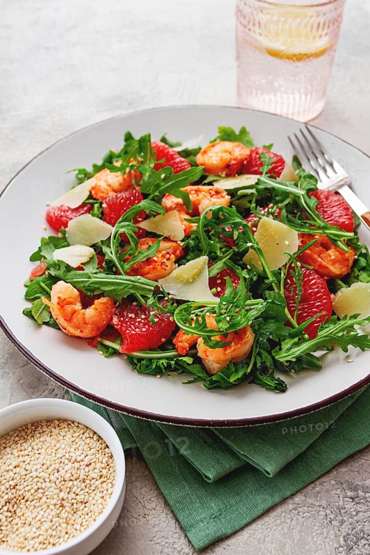 Fresh shrimp salad with arugula, grapefruit, and parmesan served in a bowl