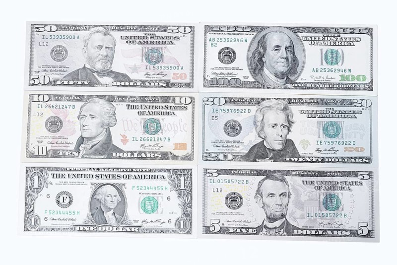 Various US dollar notes on white background, 1 dollar, 5 dollars, 10 dollars, 20 dollars, 50 dollars, 100 dollars, banknotes