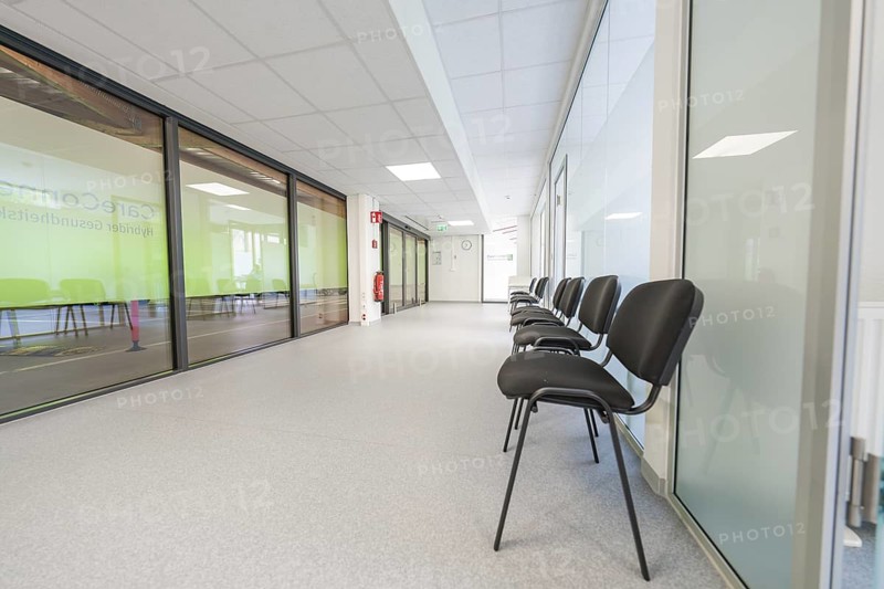 Modern, bright hallway with chairs and glass doors in the waiting area, Care Connect, vaccination kiosk for refugees, Calw, Germany