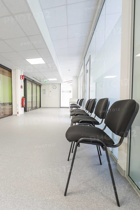 Bright corridor with chairs in the waiting area and modern glass walls, Care Connect, vaccination kiosk for refugees, Calw, Germany