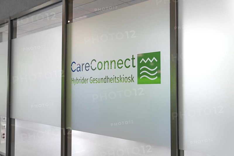 Glass wall with CareConnect logo in modern design and health kiosk lettering, Care Connect, vaccination kiosk for refugees, Calw, Germany