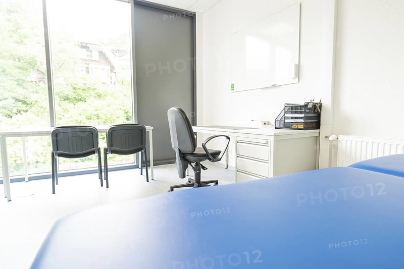 Bright office space with desk and chairs in front of large windows, Care Connect, vaccination kiosk for refugees, Calw, Germany