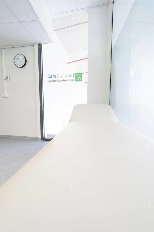 Treatment room with couch and CareConnect logo in minimalist style, Care Connect, vaccination kiosk for refugees, Calw, Germany