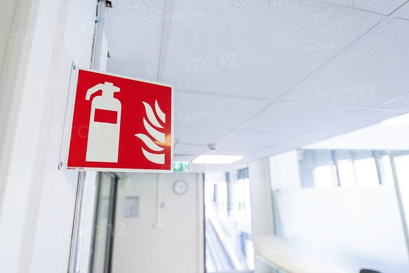 Safety sign for fire extinguisher installed in an office corridor, Care Connect, vaccination kiosk for refugees, Calw, Germany