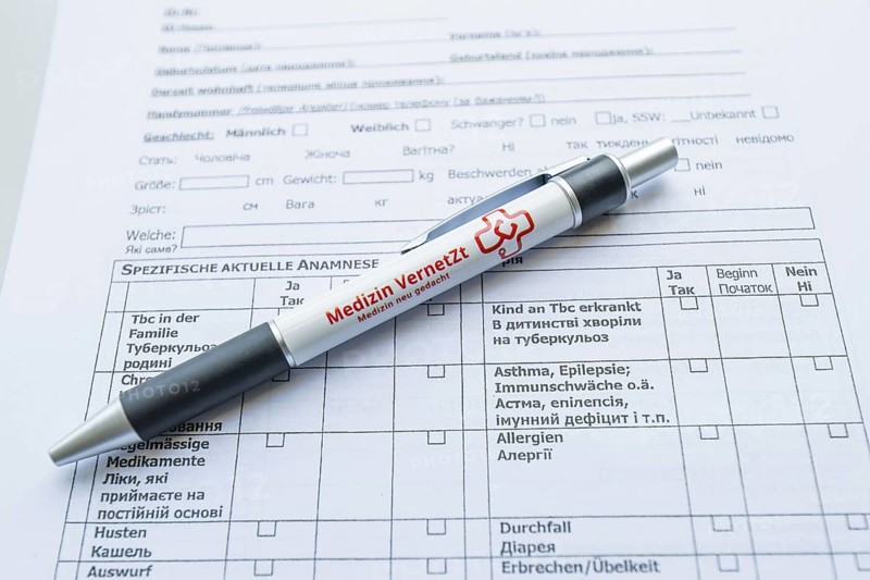 Biros lying on a medical form on a desk, Care Connect, vaccination kiosk for refugees, Calw, Germany