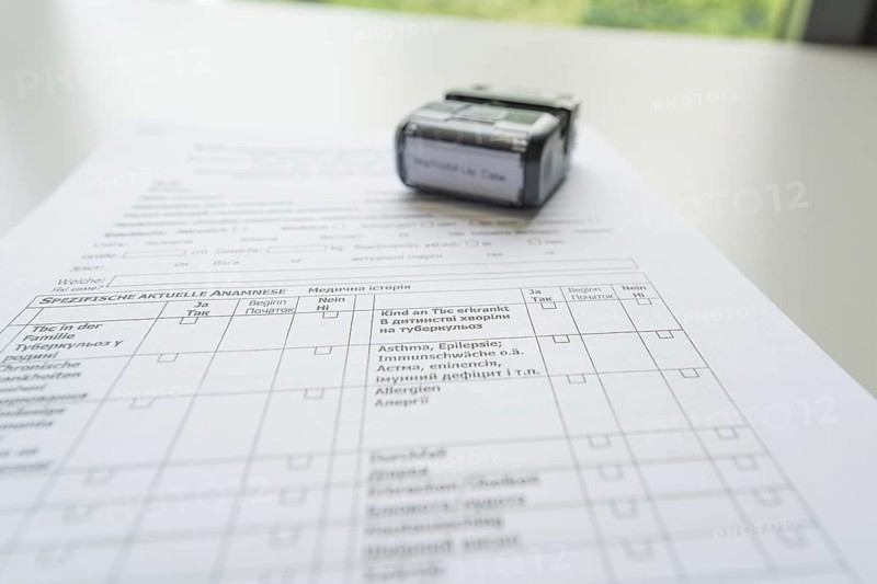 A completed form with a stamp on it, Care Connect, vaccination kiosk for refugees, Calw, Germany