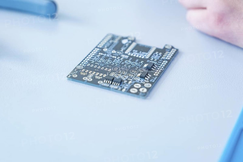 Close-up of a circuit board on a table in focus, blurred background