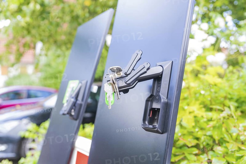 Black panels with a bunch of keys on a lock, installation of a charging station for electric cars, Calw, Germany