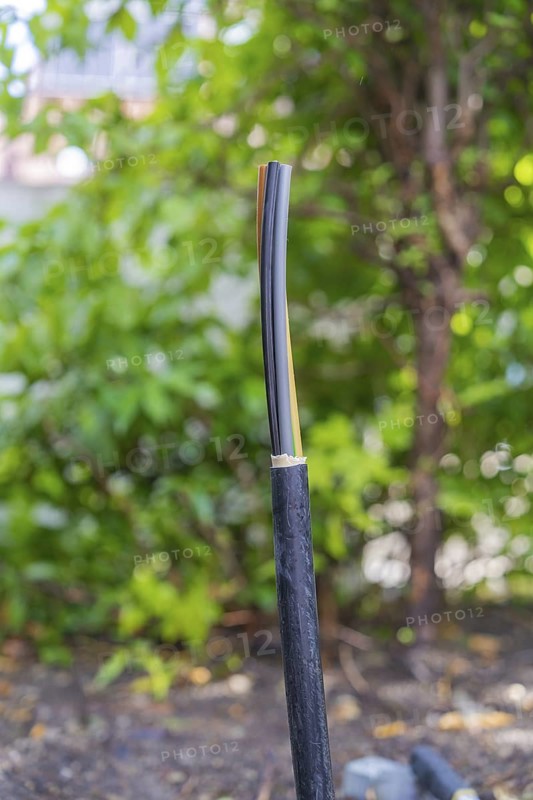 Single cable, insulated, protruding in natural surroundings, installation of a charging station for electric cars, Calw, Germany