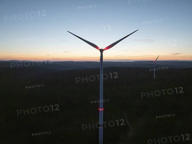 A wind turbine in front of a colourful evening sky with the silhouette in the darkness, Simmersfeld, Black Forest, Germany