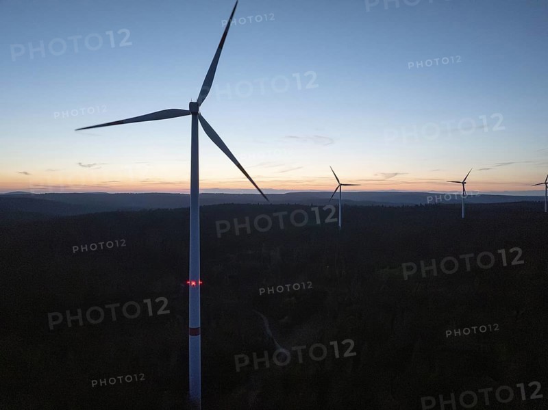 Several wind turbines on the horizon during a sunset, the sky is coloured in warm tones, Simmersfeld, Black Forest, Germany