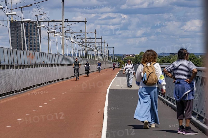 Cycle and pedestrian bridge Snelbinder Brug, over the river Waal near Nijmegen, was added to the existing railway bridge, fast cycle path connection from the city centre of Nijmegen and the new housing estates in the Waalsprong district, Netherlands