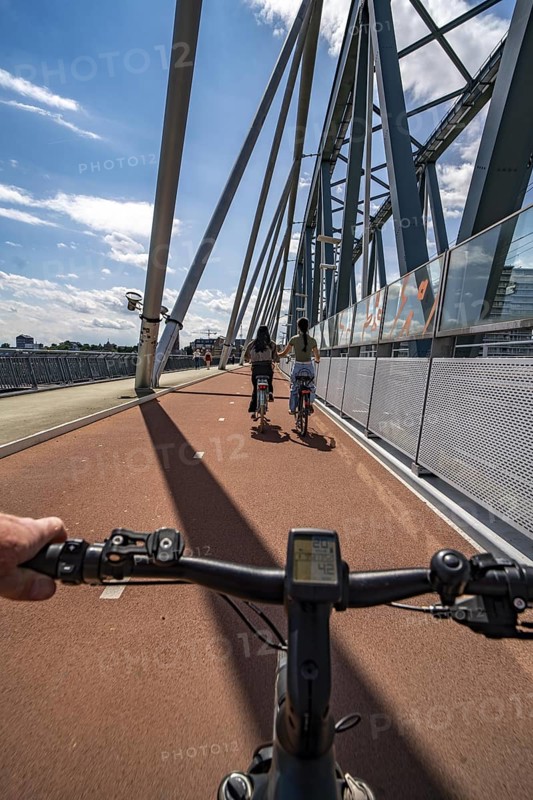 Ride over the Snelbinder Brug bicycle and pedestrian bridge, over the river Waal near Nijmegen, was built on the existing railway bridge, fast cycle path connection from the city centre of Nijmegen and the new housing estates in the Waalsprong district, Netherlands