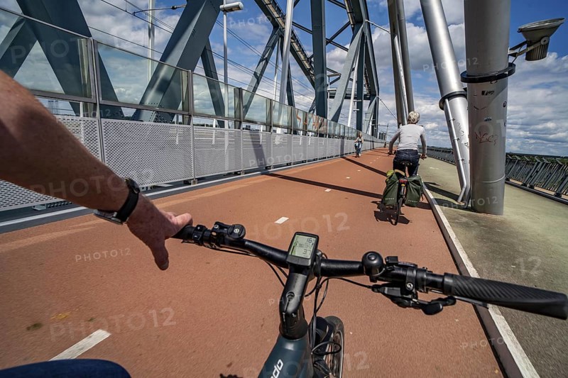 Ride over the Snelbinder Brug bicycle and pedestrian bridge, over the river Waal near Nijmegen, was built on the existing railway bridge, fast cycle path connection from the city centre of Nijmegen and the new housing estates in the Waalsprong district, Netherlands