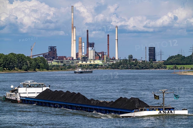 Industrial scenery of the ThyssenKrupp Steel steelworks in Duisburg-Bruckhausen, cargo ships on the Rhine, freighter Anja I, loaded with coal, blast furnaces, coking plant Schwelgern, Duisburg, North Rhine-Westphalia, Germany