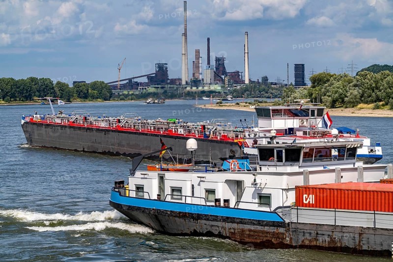 Industrial backdrop of the ThyssenKrupp Steel steelworks in Duisburg-Bruckhausen, cargo ships on the Rhine, blast furnaces, Schwelgern coking plant, Duisburg, North Rhine-Westphalia, Germany