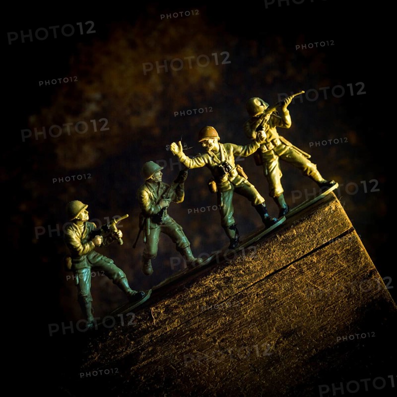 A group of toy soldiers are captured in motion as they navigate a steep incline, showcasing teamwork and strategy
