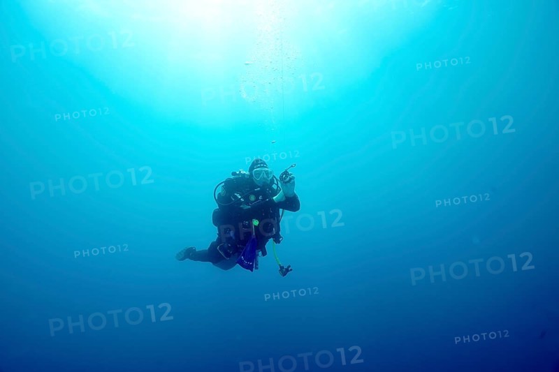 A diver floats alone during a safety stop in the blue depths of the Mediterranean Sea near Hyères, Giens Peninsula dive site, Provence Alpes Côte d'Azur, France