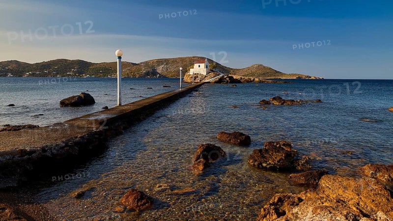 A stone pier leads to a church standing on a rock in the calm sea, chapel, church, Agios Isidoros, rocky islet, Gourna Bay, Kokkali, Leros, Dodecanese, Greek Islands, Greece