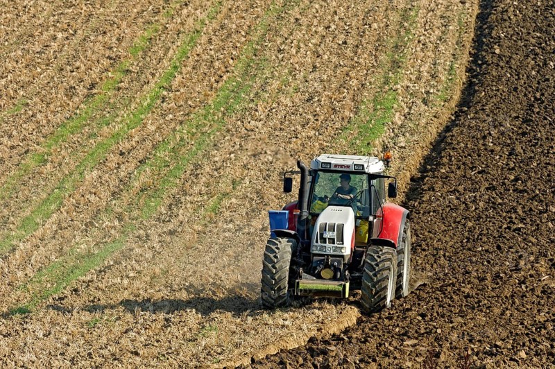 Harvested grain field being turned into a field by Steyr tractor with plough, Hohenpolding, Erding, Upper Bavaria, Bavaria, Germany