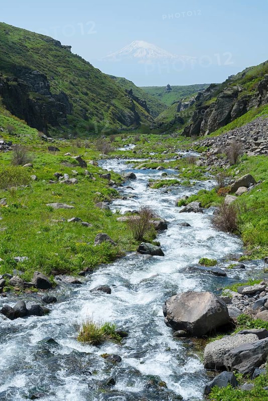 Clear stream flows through a green, rocky landscape with mountains in the background, Our Lady Church with Ararat in the background, Vahramashen Church, Vahramashen Surp Astvatsatsin, Amberd Church, Amberd Gorge, Aragazotn Province, Armenia