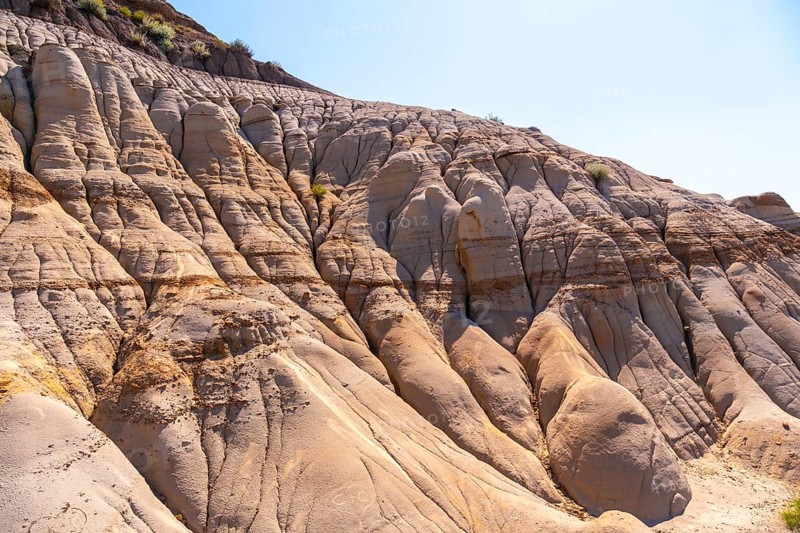 Sunlight illuminates the unique geological formations known as hoodoos. Showcasing layers of sedimentary rock and erosion patterns in drumheller. Alberta. A testament to the power of nature over time