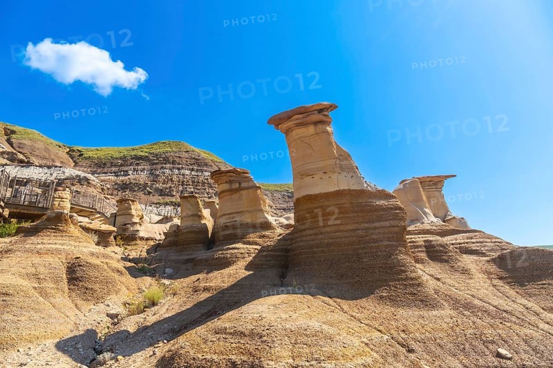 Breathtaking sandstone hoodoos rise majestically in drumheller valley, showcasing unique geological formations under a vibrant blue sky, creating a stunning landscape in the canadian badlands
