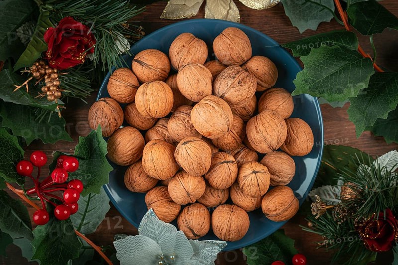 Blue plate with walnuts surrounded by Christmas decoration