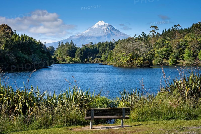 Park bench on Lake Mangamahoe with views of Mount Taranaki. Egmont National Park, Taranaki Region, North Island, New Zealand