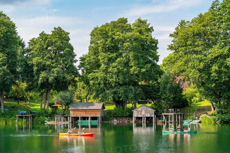 Carwitz Lake with paddlers and boathouses, Feldberger Seenlandschaft, Mecklenburg Lake District, Mecklenburg-Western Pomerania, Germany