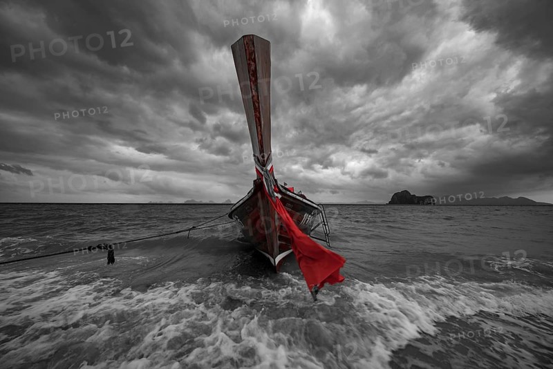 Longtail boat on the beach with dark rain clouds behind it, Koh Ngai island, Andaman Sea, Satun province, southern Thailand, Thailand