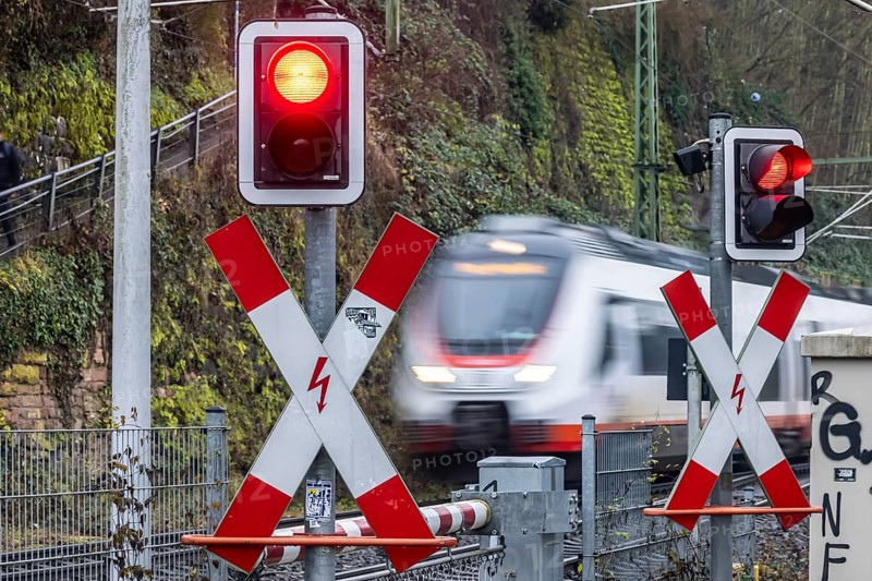 Rail crossing with regional train at Bad Wimpfen station. Flashing light, St. Andrew's Cross and barrier. Bad Wimpfen, Baden-WÃ¼rttemberg, Germany