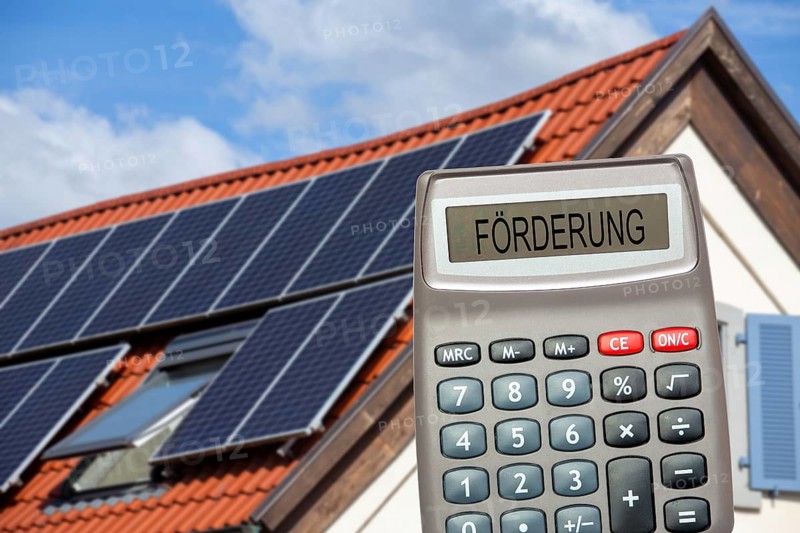 (photo montage) Pocket calculator with the inscription PROMOTION in front of a solar roof