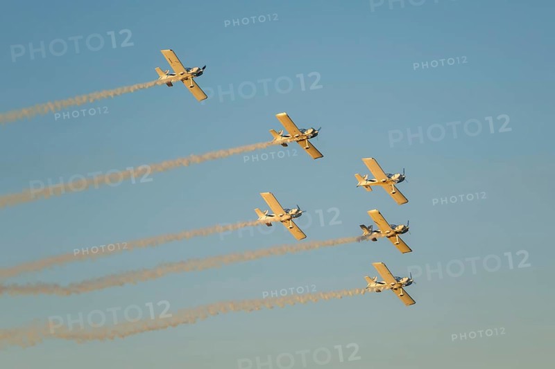 Stunt aerobatic planes performing stunts in blue sky with smoke trail. Concept of teamwork, collaboration, coordination, trust, precision, difficulty, challenge, speed, synergy