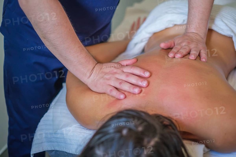 A woman enjoys a soothing back massage from a skilled therapist using oil for relaxation and lymphatic drainage in a spa salon