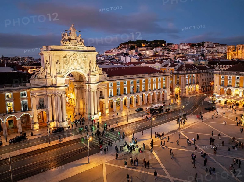 Experience the magic of Christmas in Lisbon as Praca do Comercio glows with festive lights in the evening twilight